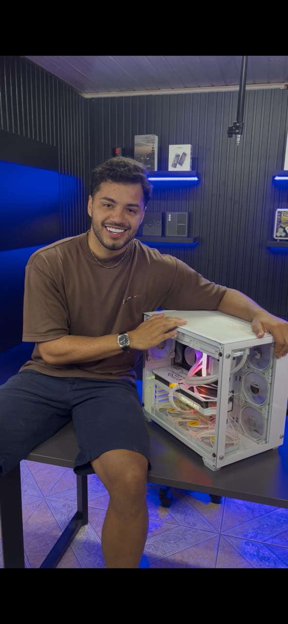 Henrique sorrindo ao lado do computador de edição