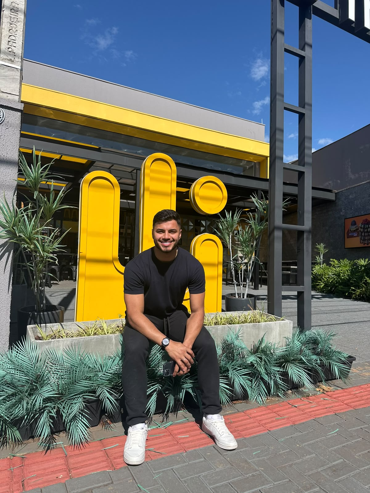 Henrique Martins Kunz no treinamento da The Best em Londrina, sentado diante do símbolo amarelo da marca